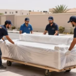 فريق متخصص في نقل أثاث من الدمام إلى الرياض يقوم بتغليف قطع الأثاث بعناية